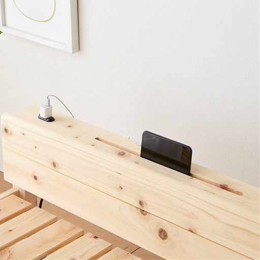 ヘッドボードにはスマホスタンドになる溝加工があります。充電もできるコンセント付き。
