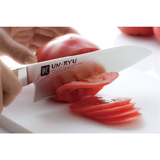 (三徳包丁使用例)手になじみ温かみある木ハンドルを採用。ハンドルと刀身の接続部は精巧で水分の侵入によるサビを防ぎます。
