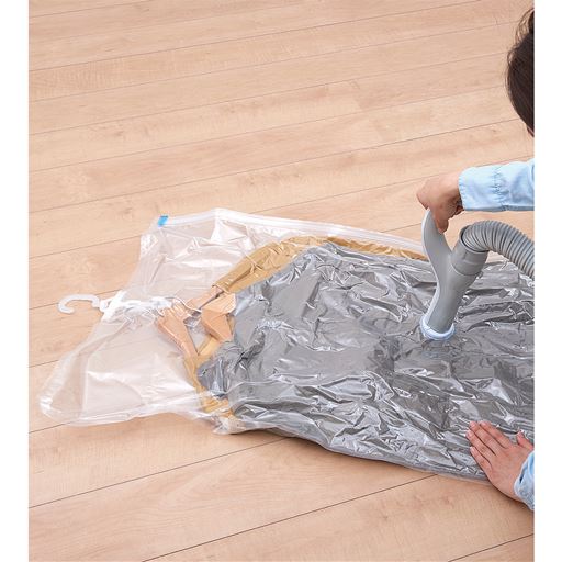 コートを袋に入れて、ハンガーごと掃除機で簡単に圧縮!