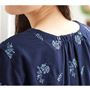 繊細なボタニカル刺しゅうがコーディネートを華やかに。背面の衿元ギャザーがさりげなく体型をカバー。