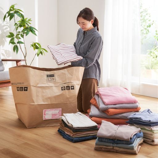 専用回収袋を広げて、衣類等を詰めてください<br>※回収袋のデザインは異なります。